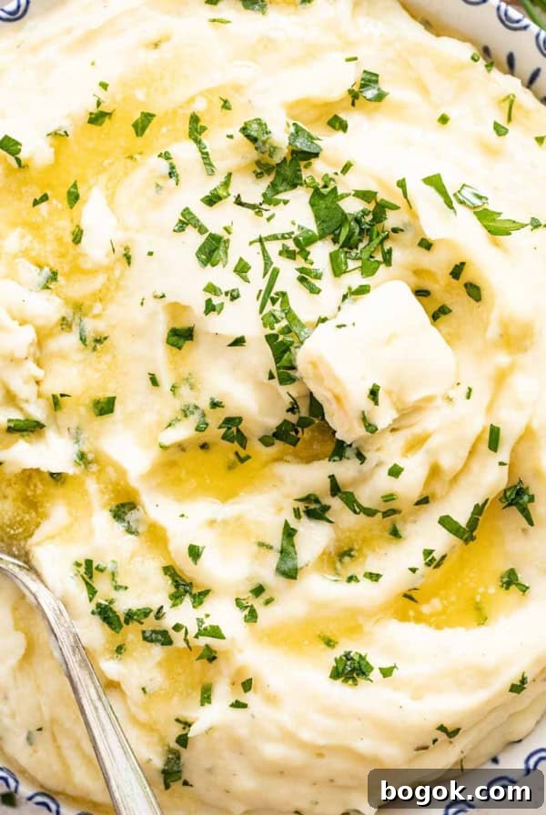 Boursin-Stuffed Mushrooms with Garlic and Herbs 11 A blue and white bowl filled with fluffy mashed Boursin Potatoes topped with chives and melted butter.