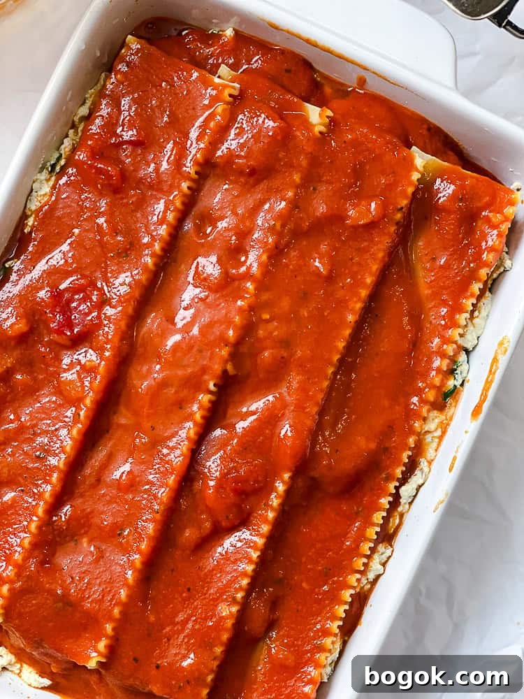 an assembled and unbaked vegan lasagna in a baking dish.