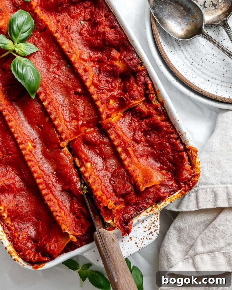 cutting a slice of vegan lasagna in a baking dish.