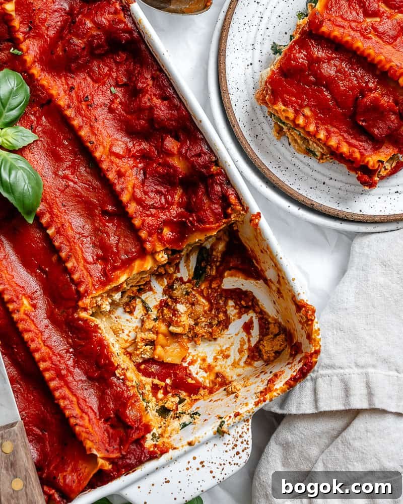 vegan lasagna in a white baking dish with a slice on a separate plate