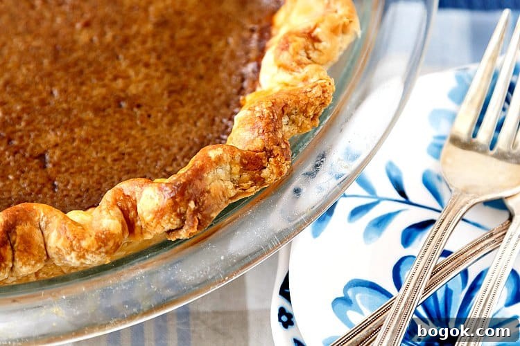 A close up of one section of chocolate caramel buttermilk pie so you can see the crimped crust.