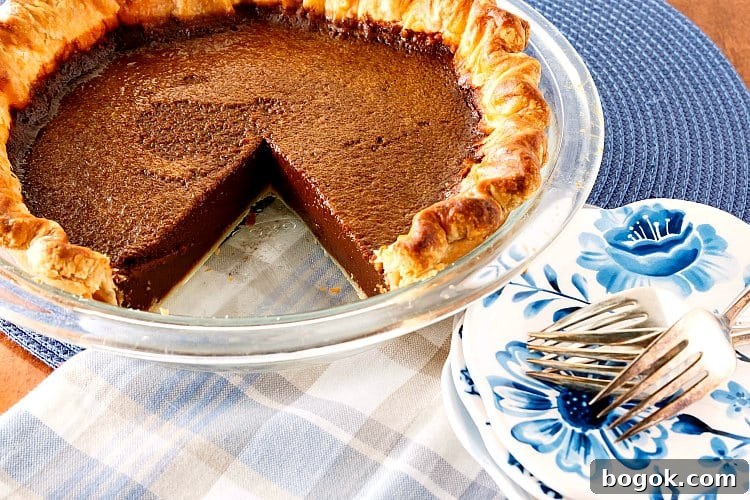 A chocolate pie with one slice cut out of it.