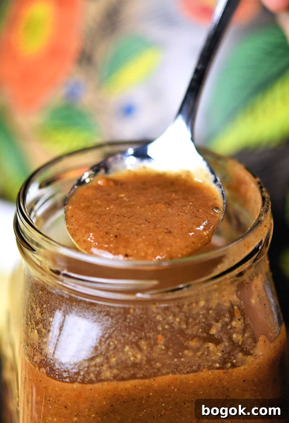 closeup of a spoonful of enchilada sauce from a glass jar
