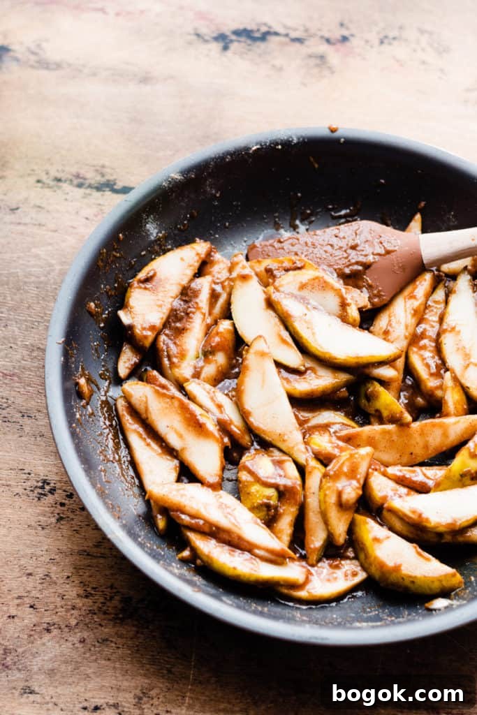 The cooked, caramelized pear filling in a pan on a wooden surface