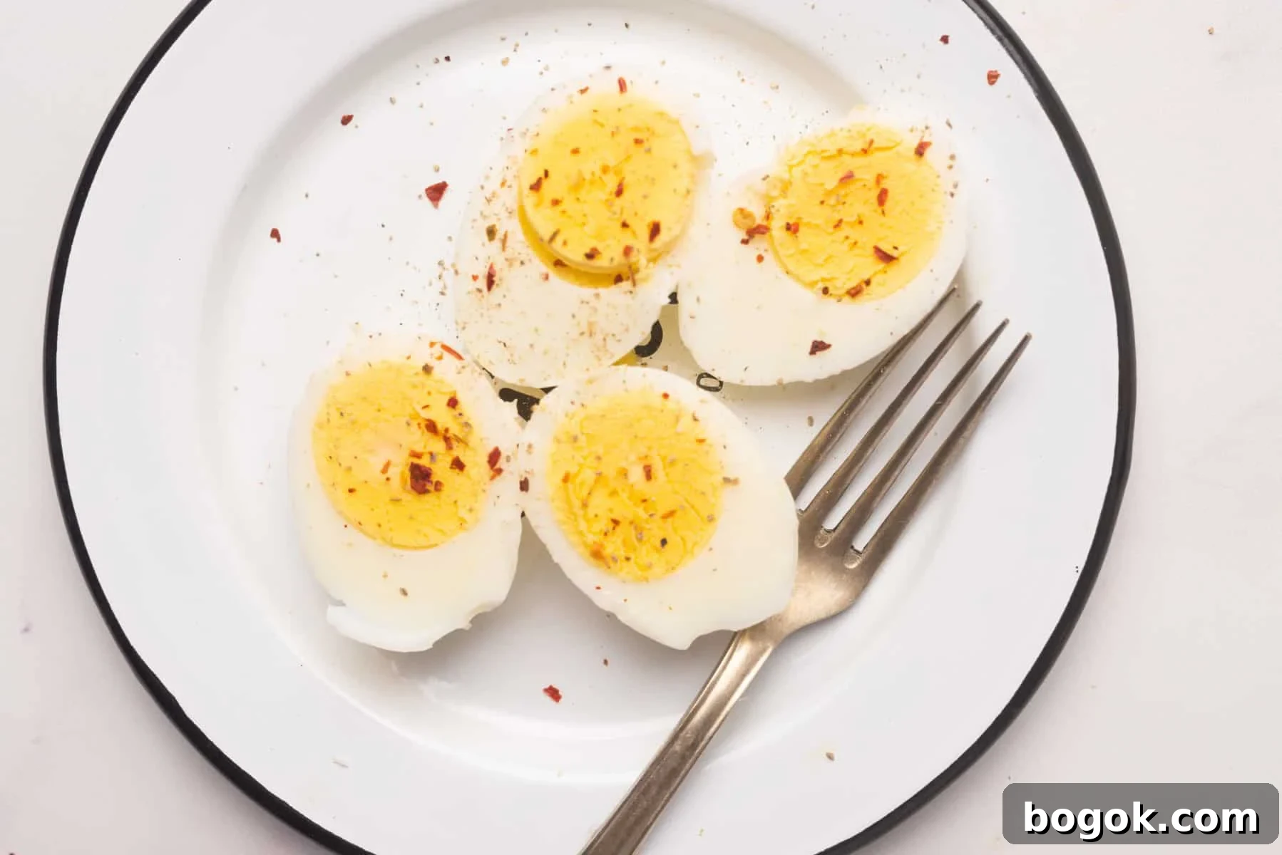 Microwave Method for Perfect Hard-Boiled Eggs in Minutes 5 Overhead view of hard boiled eggs on a white plate.
