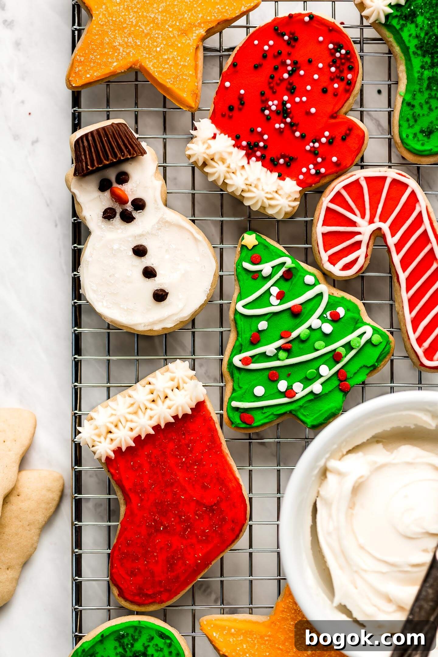 Christmas Sugar Cookie Recipes for Festive Decorating and Gifts 8 A cooling rack with Christmas Sugar Cookies frosted and decorated with sprinkles.
