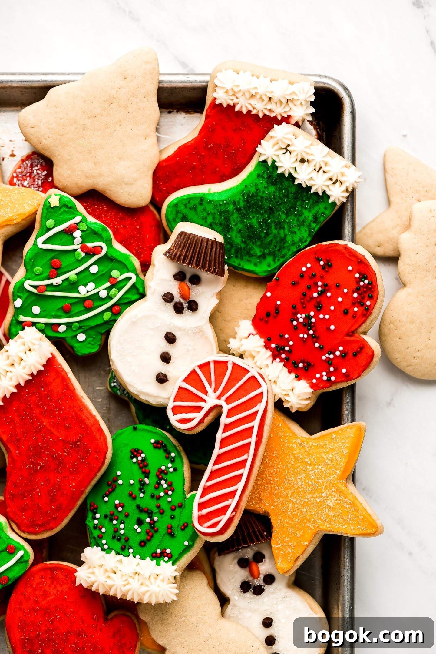 Christmas Sugar Cookie Recipes for Festive Decorating and Gifts 9 Many soft Sugar Cookies decorated for Christmas on a baking sheet.
