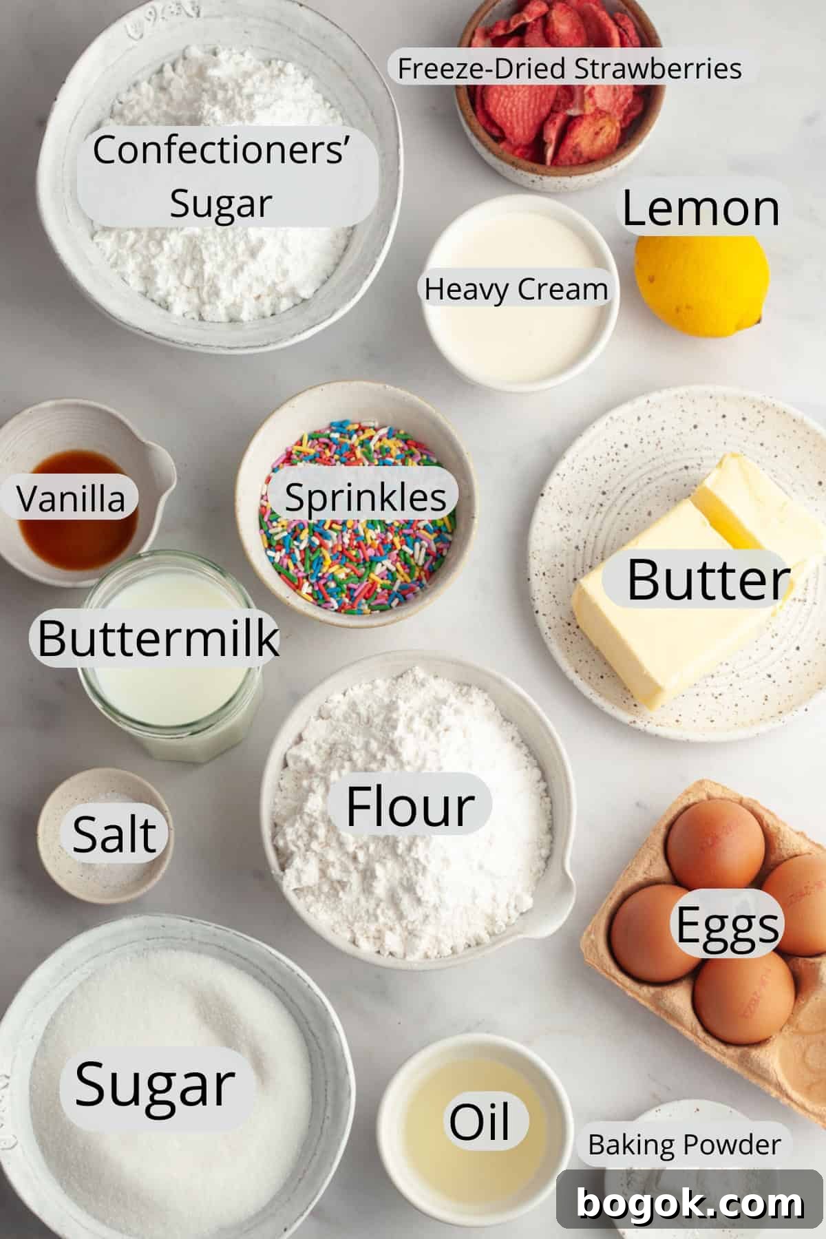 All the ingredients needed to make a strawberry funfetti cake, weighed out into small bowls.