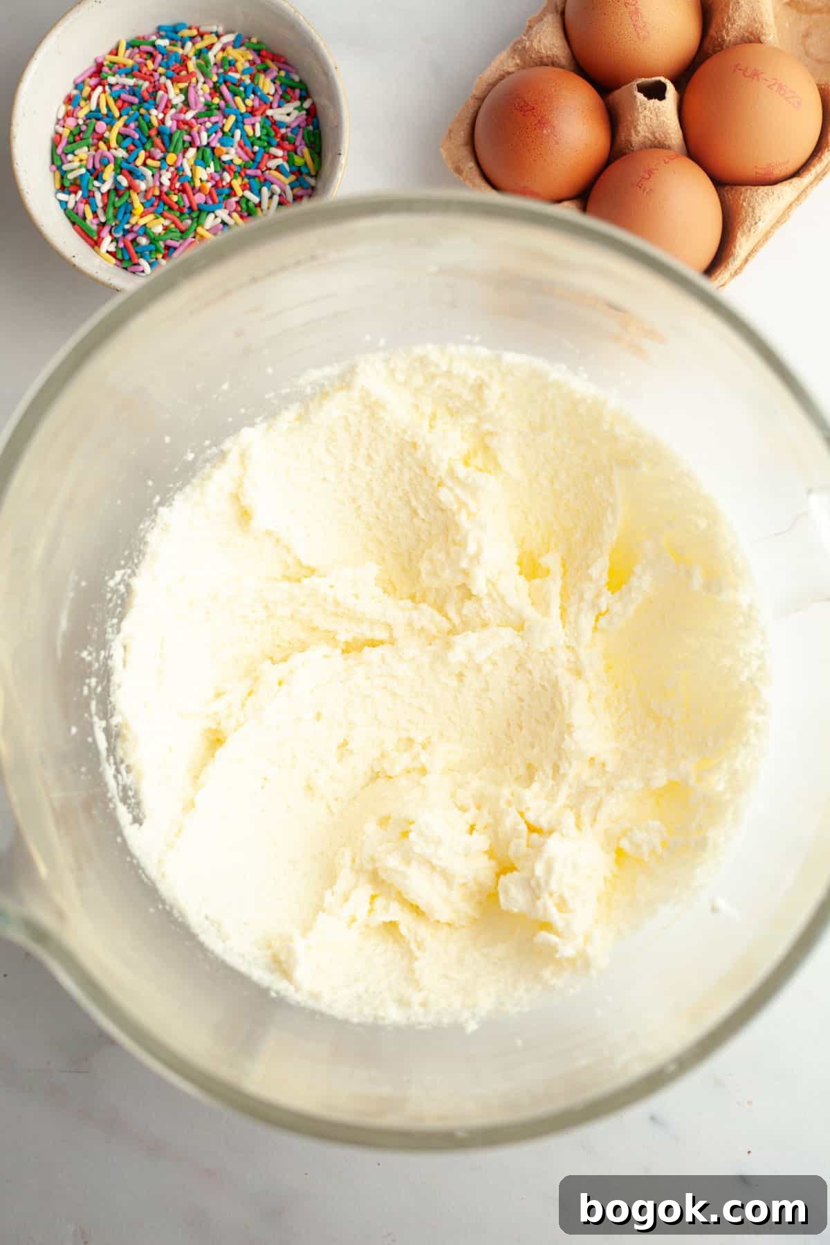 Whipped butter and sugar in a glass mixing bowl.