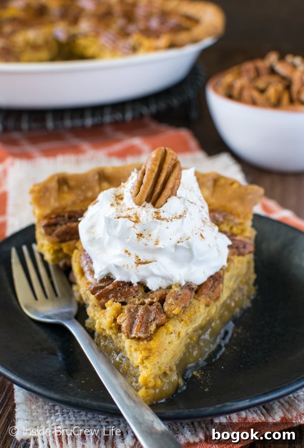 A black plate with a gooey slice of pecan pie cheesecake pie topped with whipped cream.