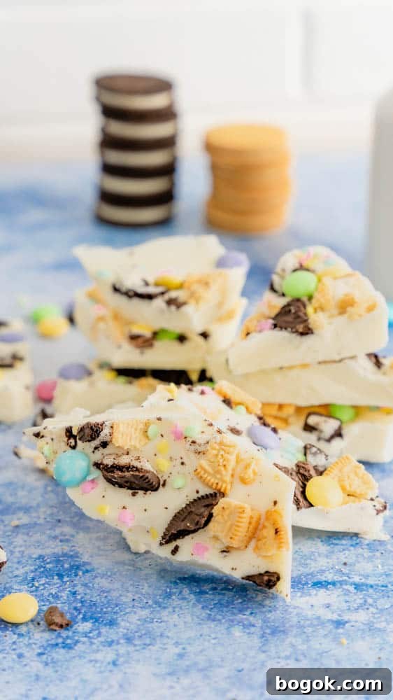 Oreos stacked behind stacks of white chocolate Easter bark. 