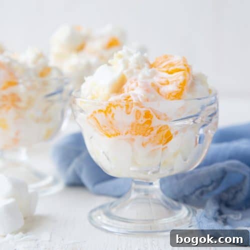 5 cup salad in a glass parfait dish with a blue tea towel nearby.