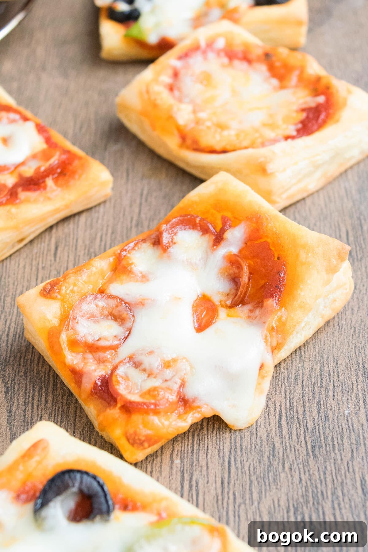 Easy mini puff pastry pizza on wood background.