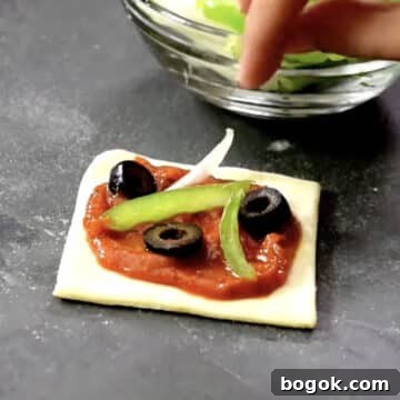 Green peppers, onions, olive toppings added to pizza.