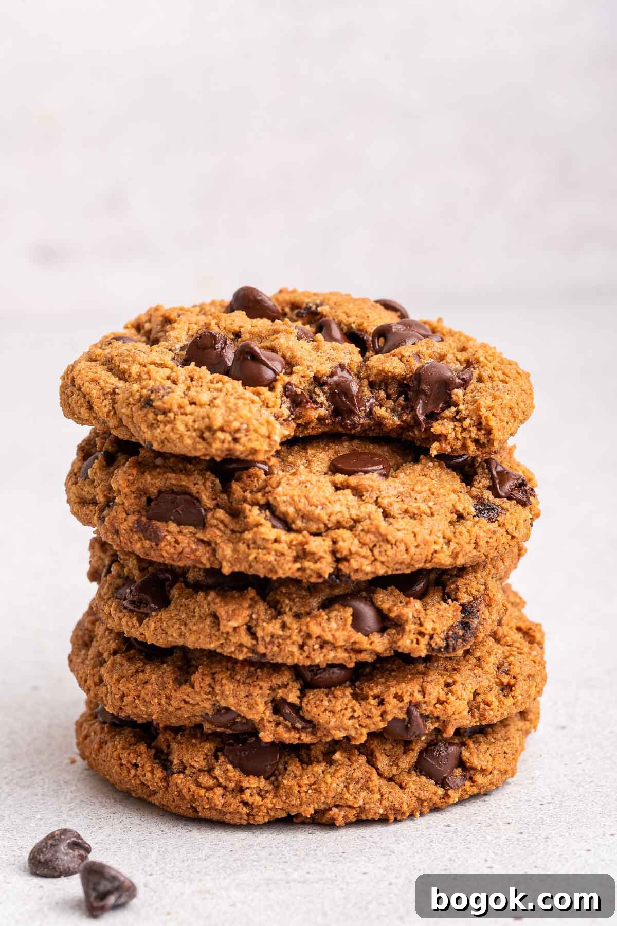 Stack of almond flour chocolate chip cookies on white counter.