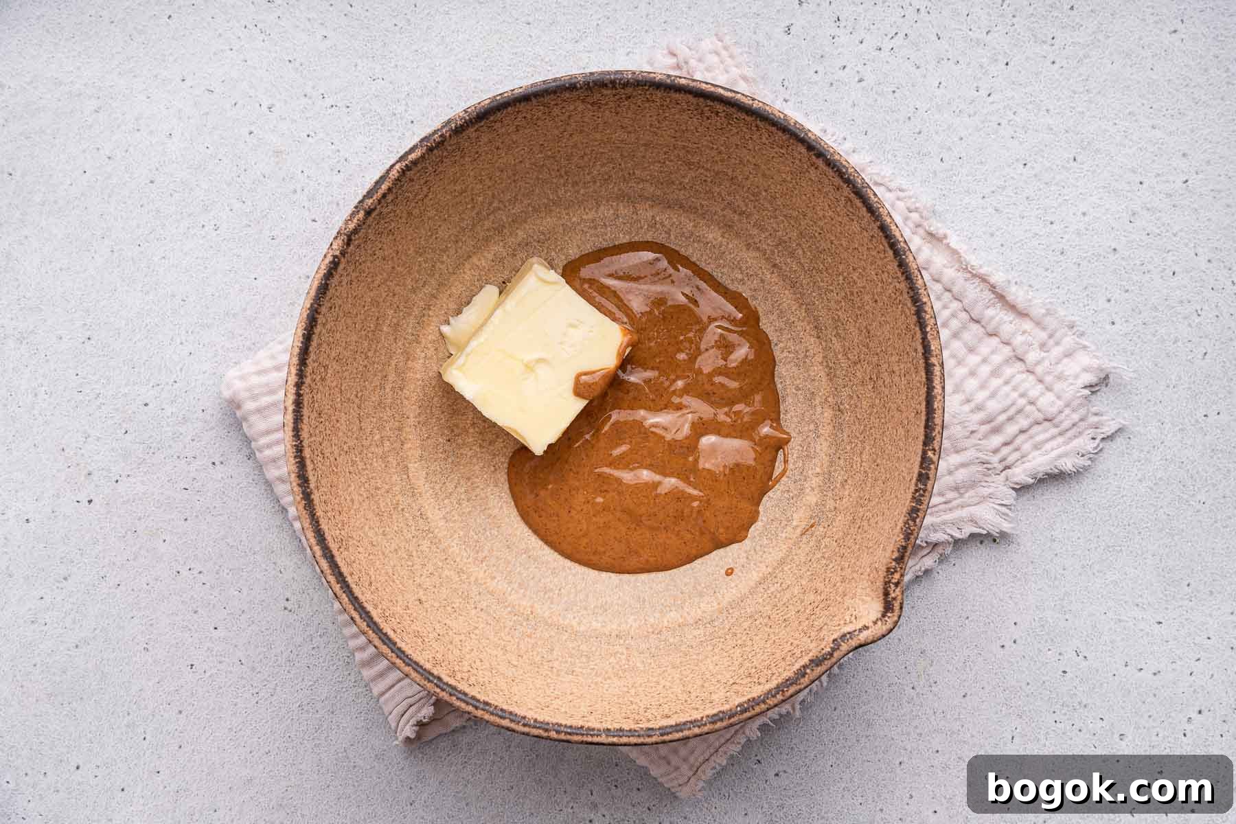 Almond butter and butter in a brown mixing bowl.