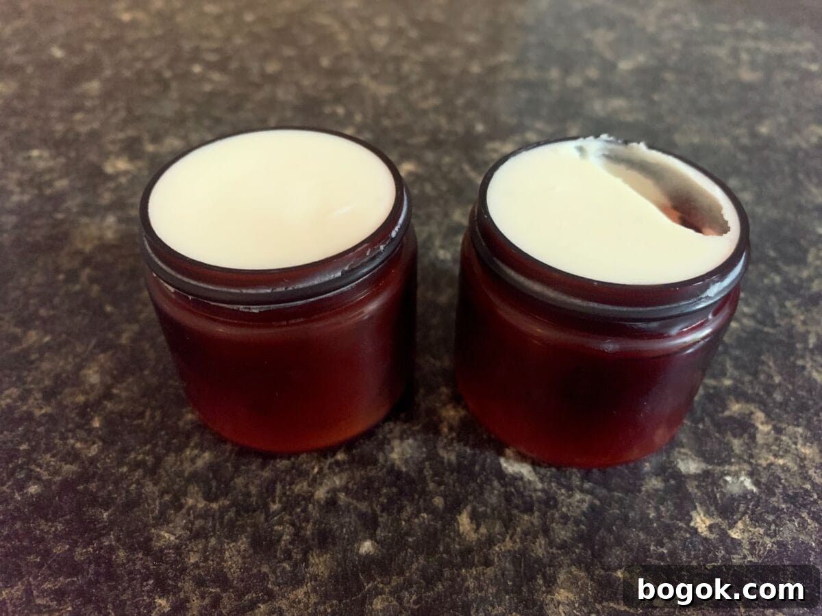 Two small, open, dark-colored jars of Whipped Cacao Body Lotion are shown on a dark countertop.