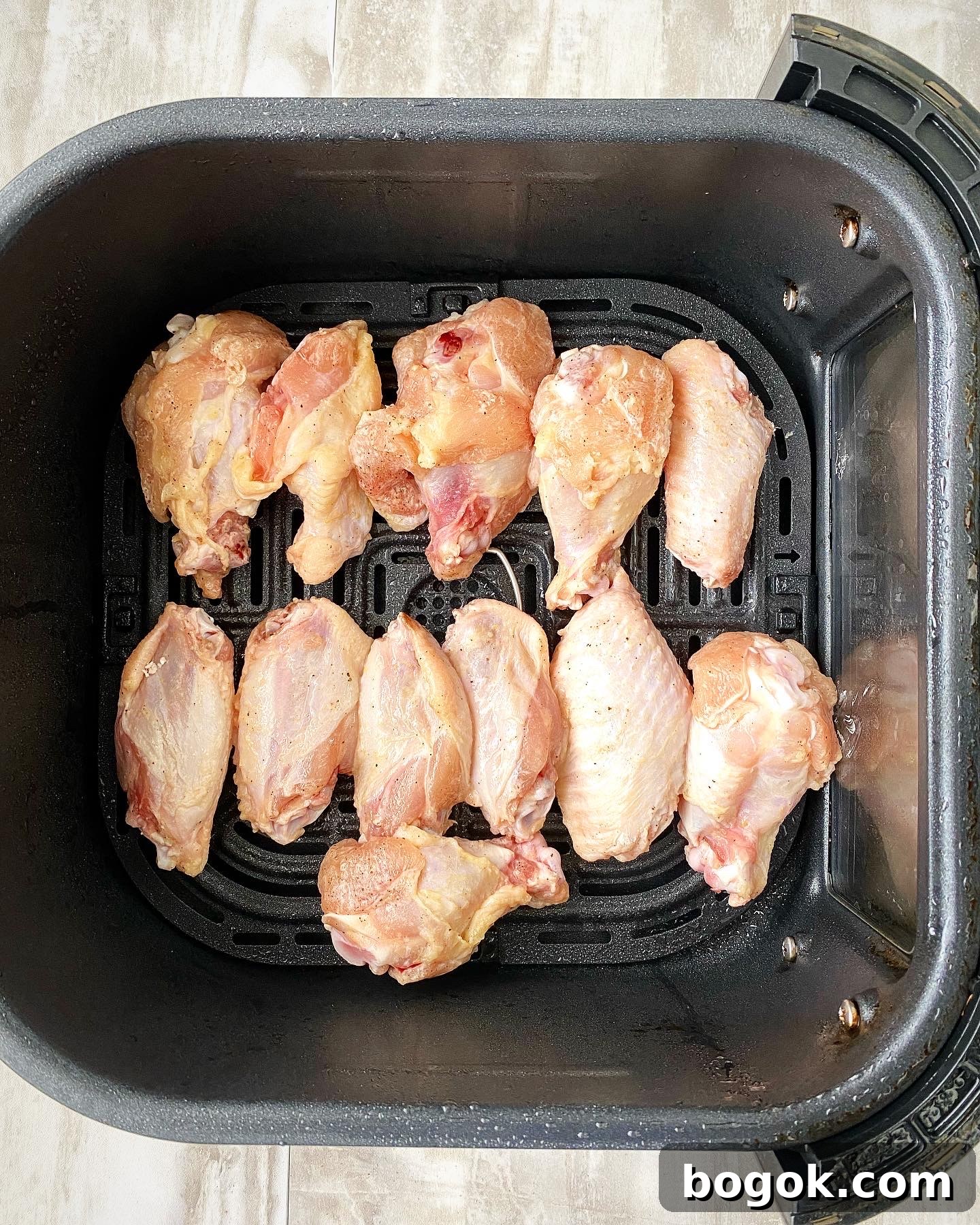 uncooked chicken wings in the air fryer basket