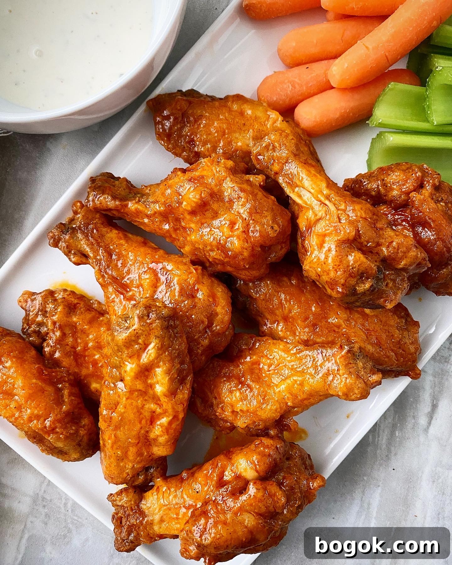 air fryer buffalo wings plated with celery, carrots, and ranch