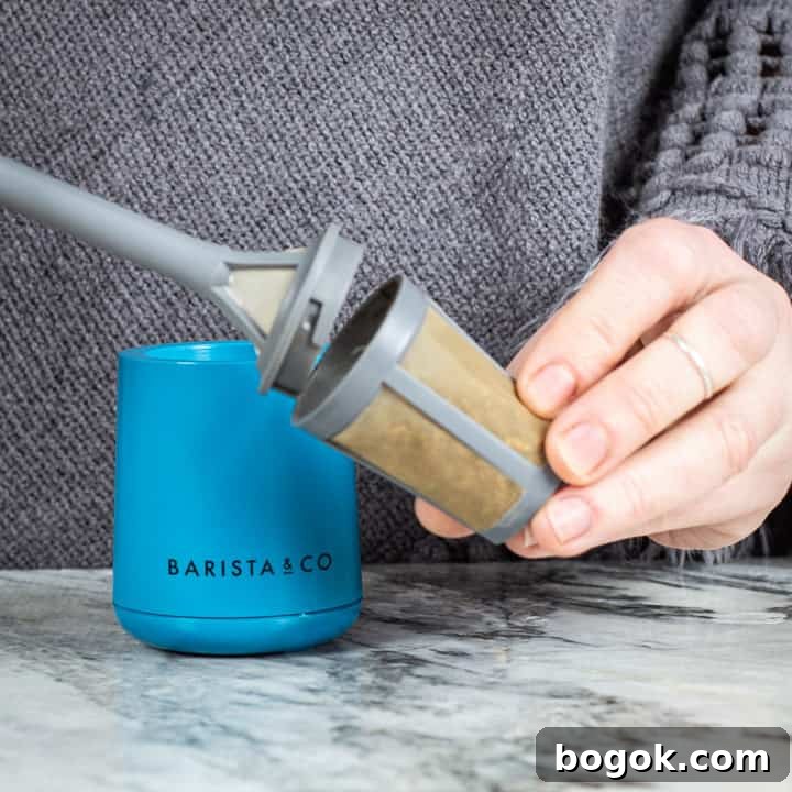 womans hands removing the basket kid from a brew it stick camping coffee maker