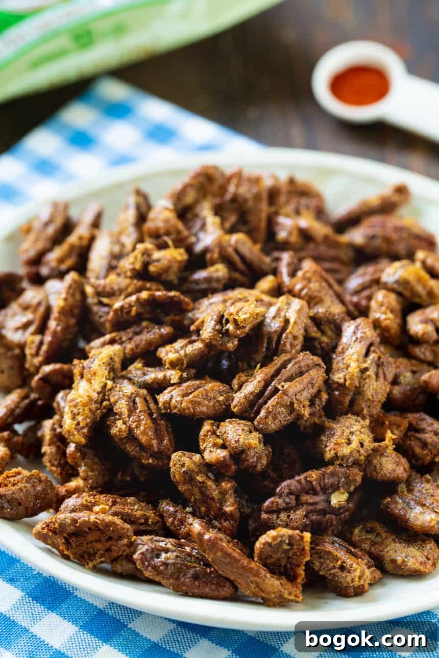 Sweet-and-Spicy Candied Pecans Recipe for Air Fryer 4 Sweet and Spicy Pecans on a white plate.