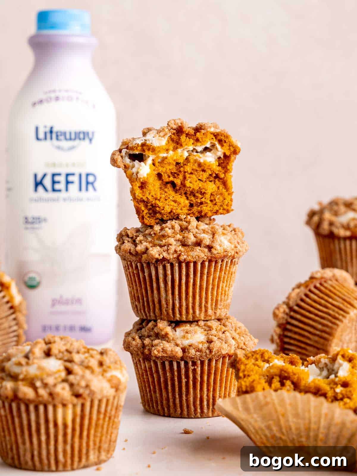 A stack of pumpkin cream cheese muffins by a bottle of Lifeway Kefir.
