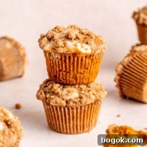 A stack of pumpkin cheesecake muffins topped with cinnamon streusel.