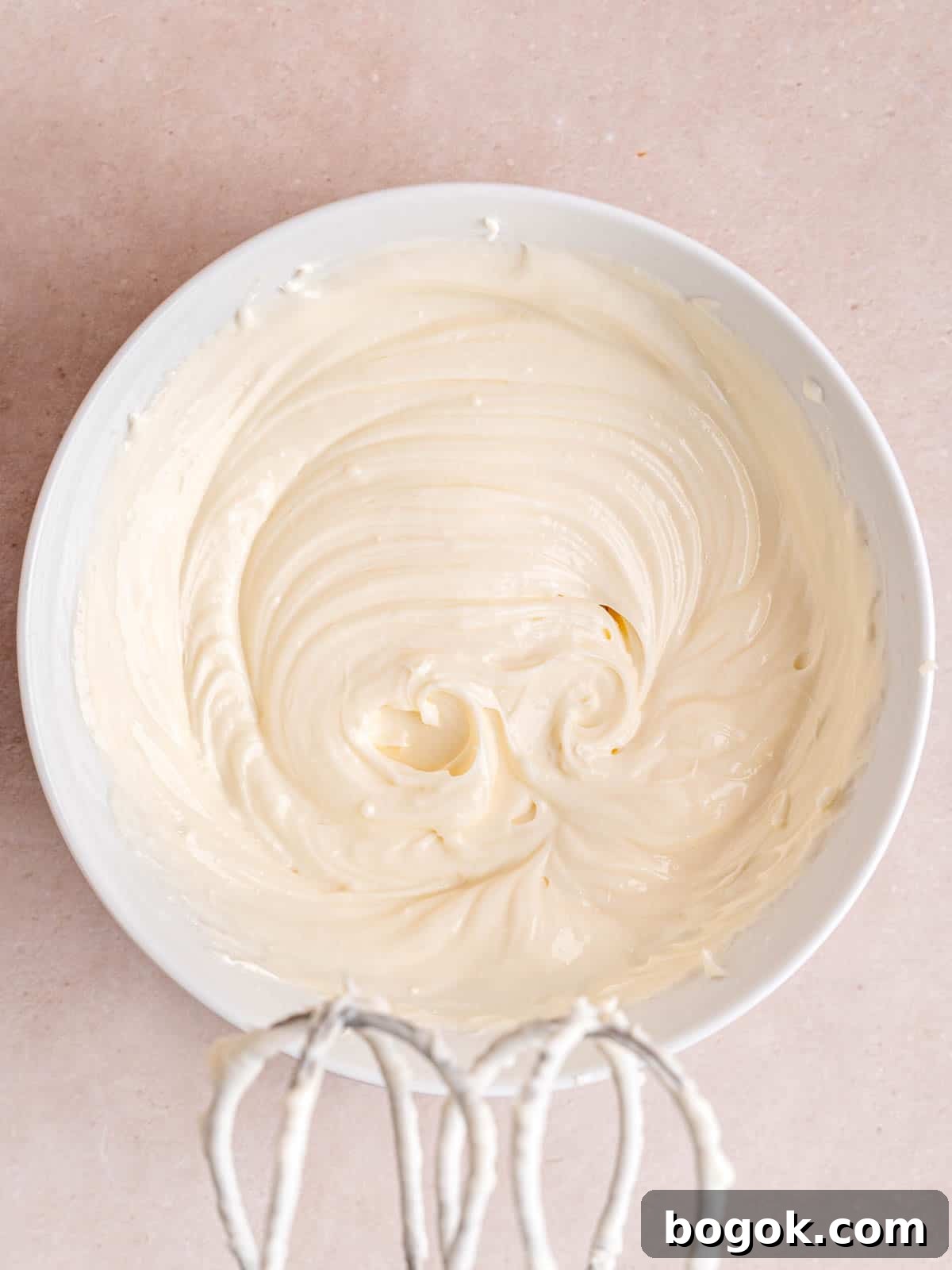 Cream cheese, sugar, and kefir mixed together in a bowl.