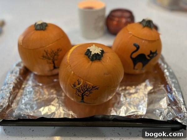Homemade Pumpkin Puree 3 pumpkins sitting on a baking sheet lined with aluminum foil