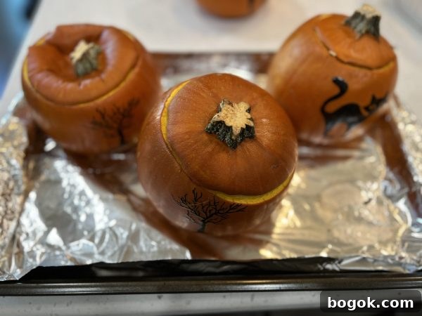 Homemade Pumpkin Puree 3 pumpkins after coming out the oven sitting on a baking sheet lined with aluminum foil