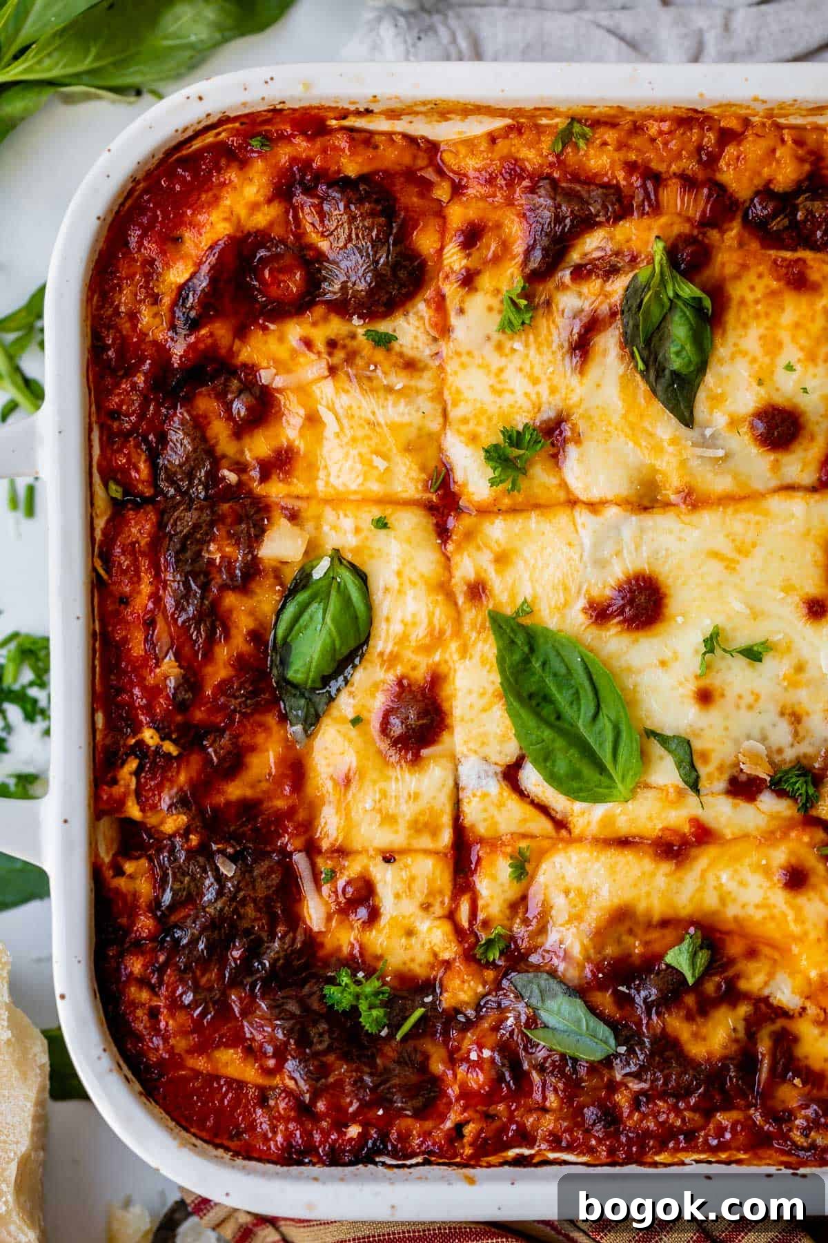 Ultimate Homemade Lasagna Recipe for Savory, Cheesy Layers 3 overhead shot of a white casserole dish with sliced lasagna.