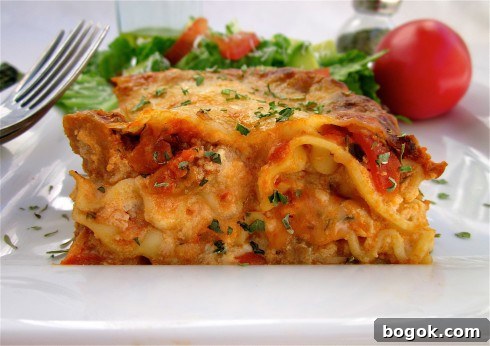 Ultimate Homemade Lasagna Recipe for Savory, Cheesy Layers 13 old fashioned lasagna on a white plate with a fork and a side salad.