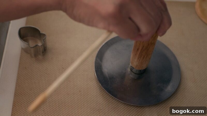 5-Minute Dalgona Candy Recipe: Quick Korean Honeycomb Toffee 13 A flat metal round disk with a wooden handle is pressing down the dalgona candy.