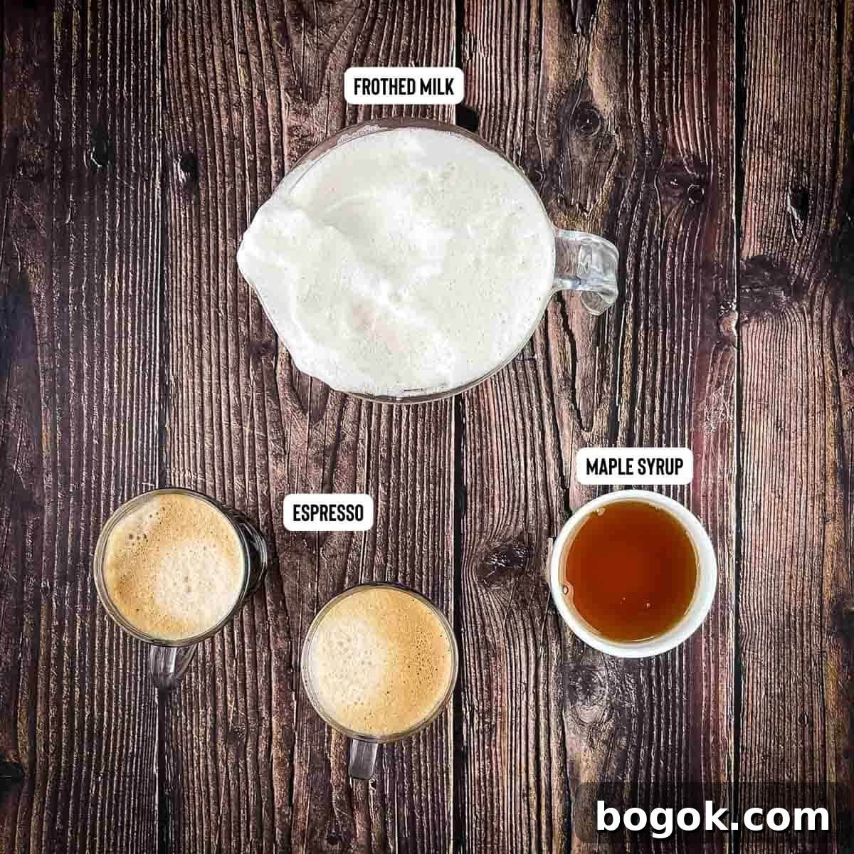 The ingredients for a homemade latte measured out and placed on a wooden table.