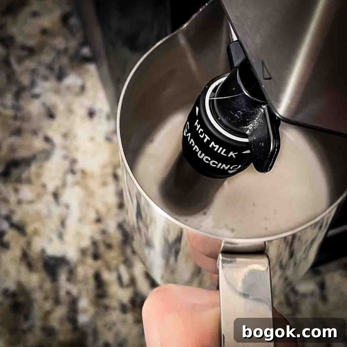 The milk being heated and frothed in a steam frother.
