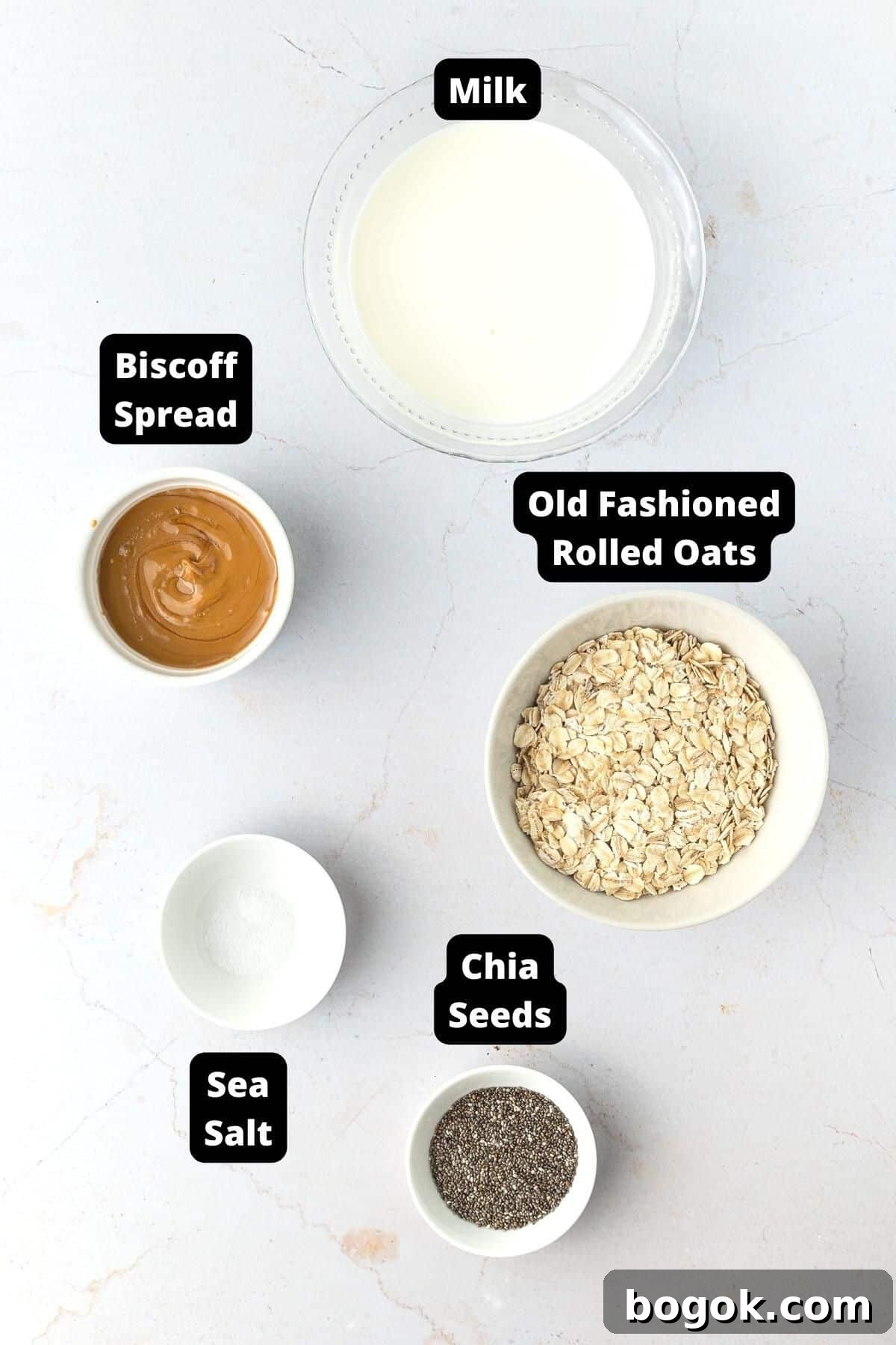 Creamy Biscoff Overnight Oats Recipe for Quick Breakfast 3 Ingredients in this recipe on a white marble background.