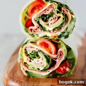 A lettuce wrap sandwich sitting on top of a wooden cutting board