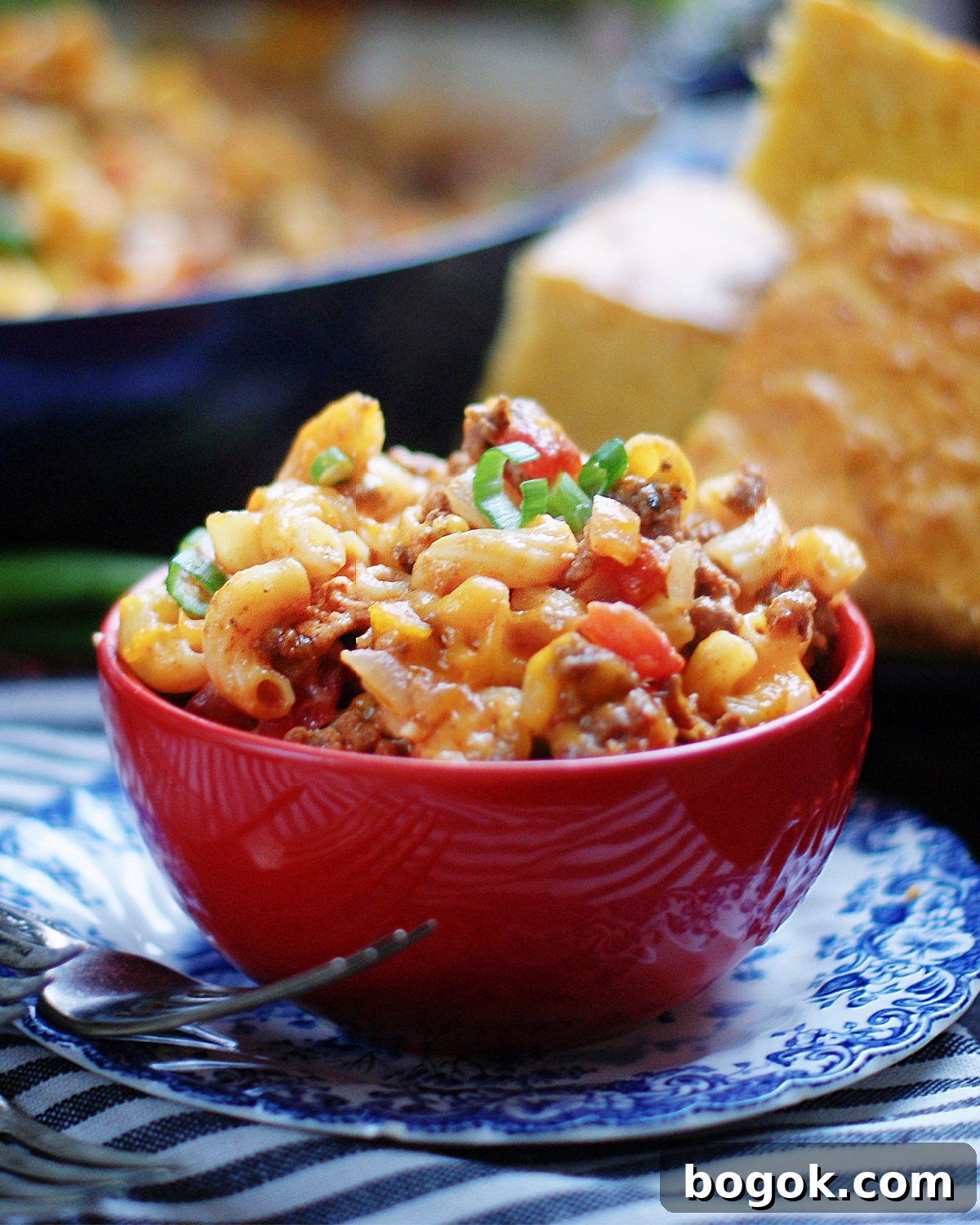 Chili Macaroni and Cheese in a bowl served with a cornbread for a complete cozy, comfort meal.