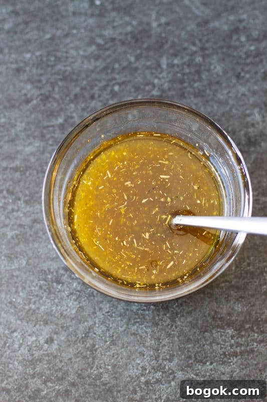Italian marinade in a glass bowl on a granite countertop.
