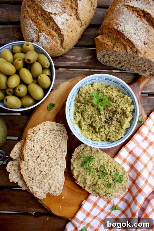 Olive Tapenade Dip with Some on the Bread Pieces, Shot from the Top