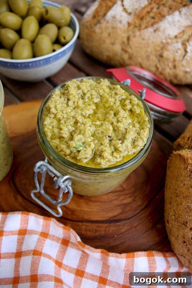 Olive Tapenade Dip with Bread and Olives around on the Table
