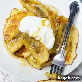 Fluffy Pancakes with Caramelized Bananas and Maple Topping 8 A plate of caramelised banana pancakes from above on a marble background - there's also a fork with a mouthful of pancake on it