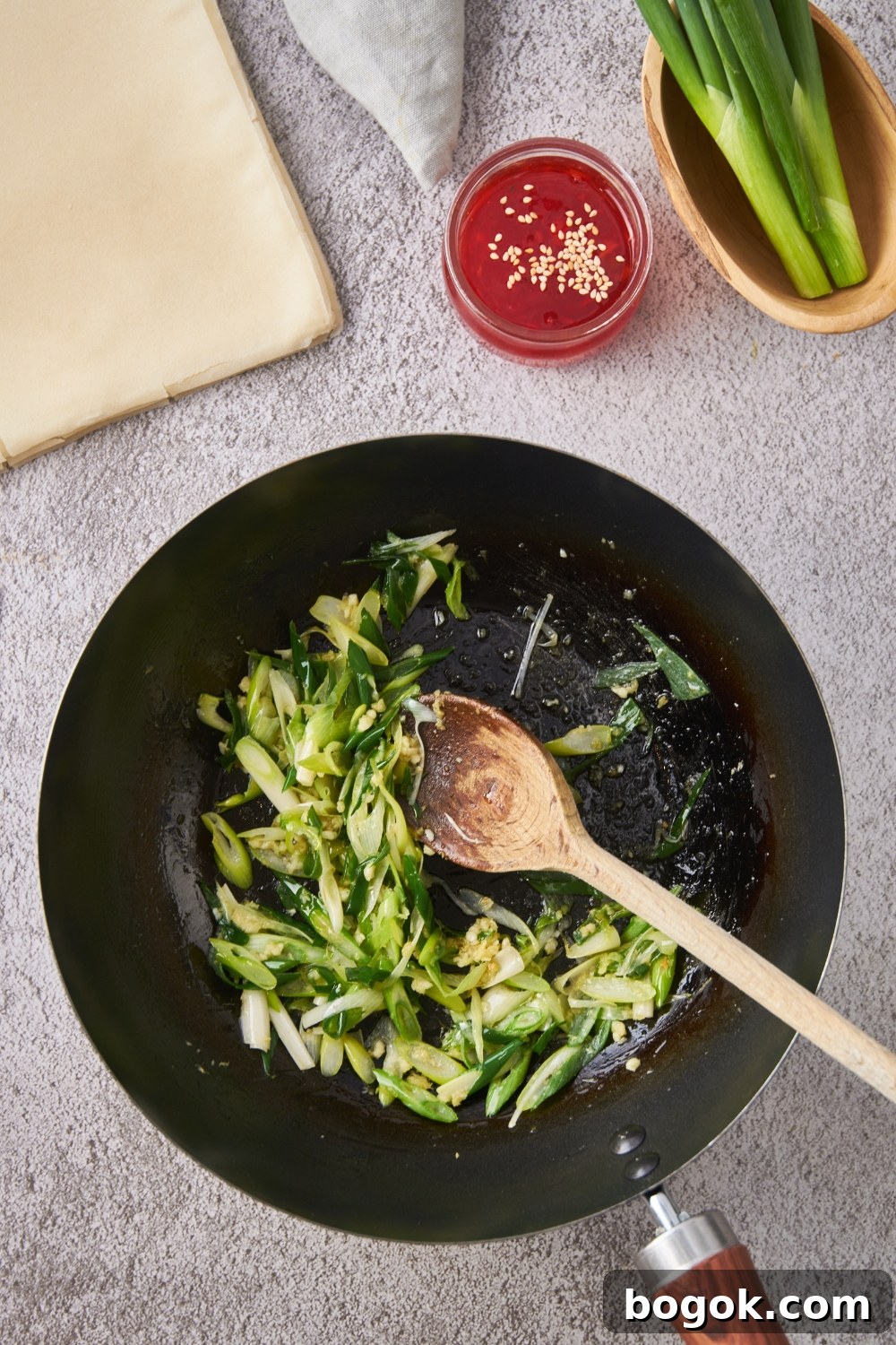 Skillet with minced garlic, ginger, and diced green onion.