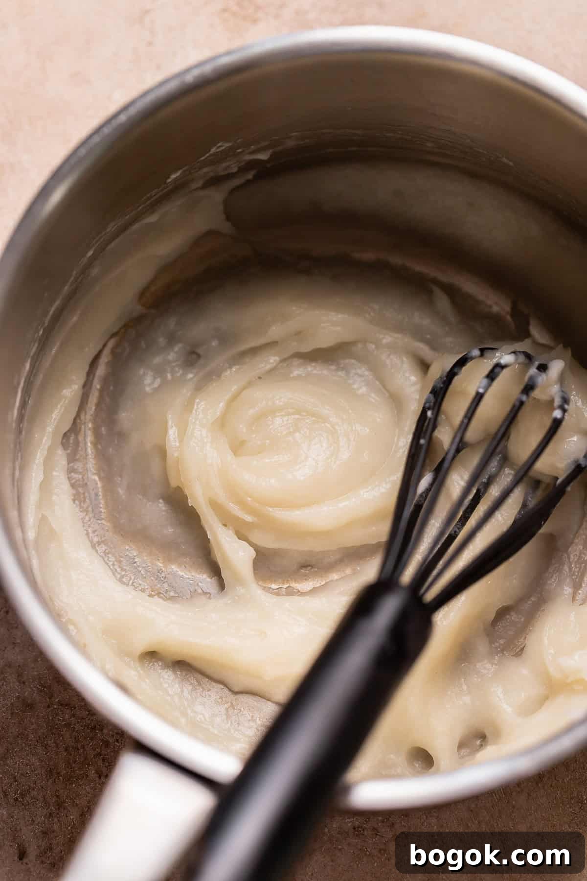 Tangzhong paste cooking in a saucepan with a whisk until thick and smooth.