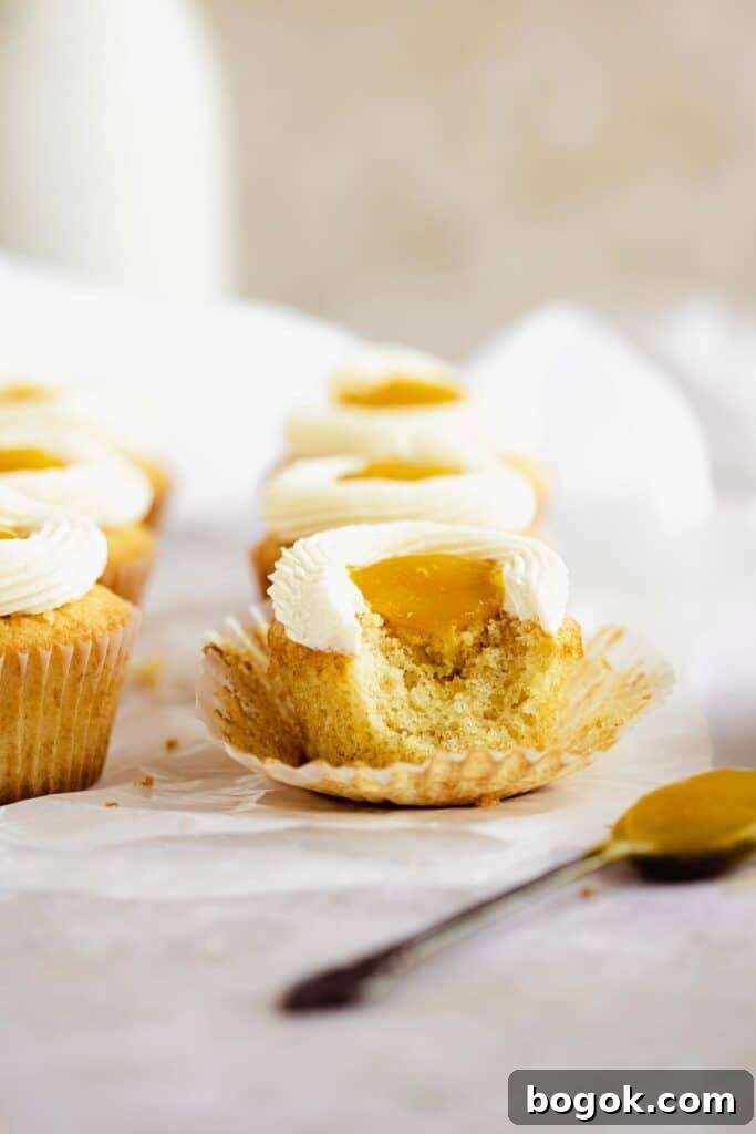 Mango Cupcakes with Luscious Mango Filling 7 a bite taken out of a cupcake with runny mango filling