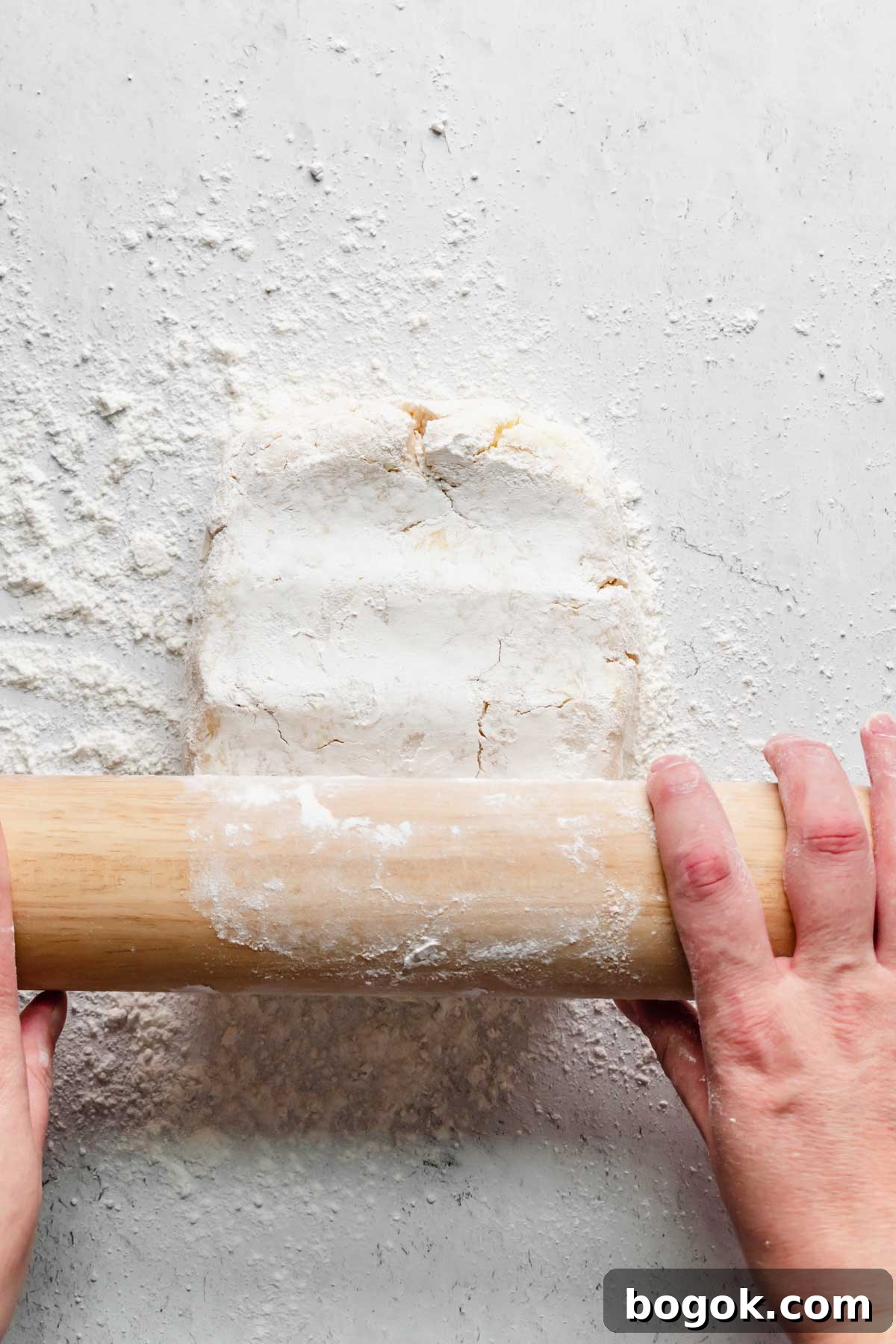 A floured rolling pin begins to roll out the dough.