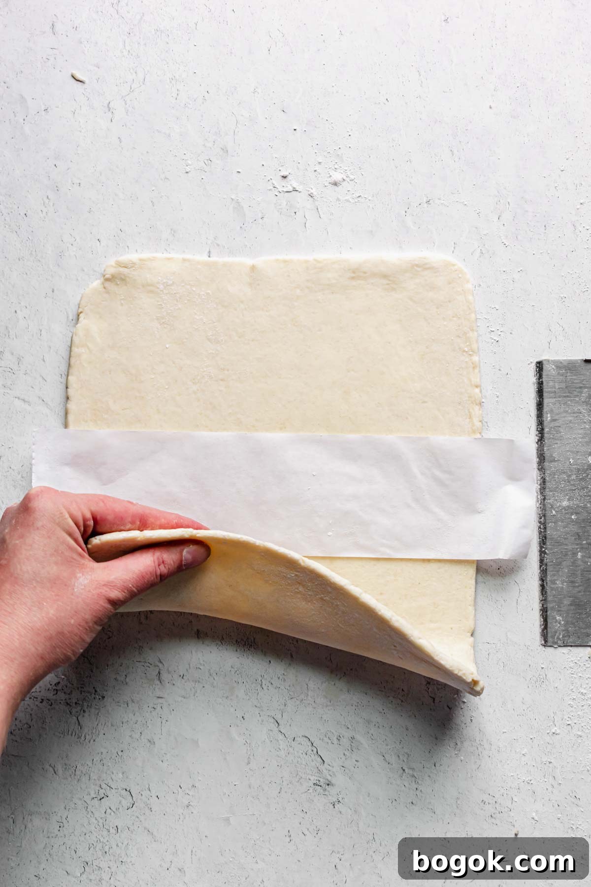 A strip of parchment paper is added to the center of the rolled out dough.