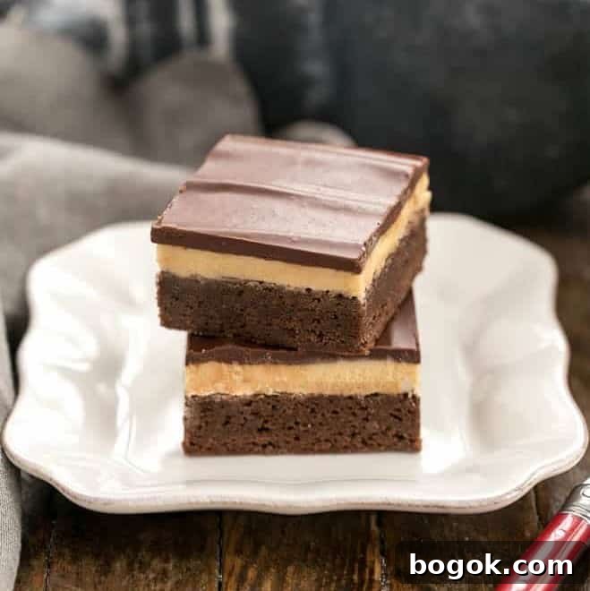 Peanut Butter Truffle Brownies - Fudgy brownies topped with a decadent peanut butter truffle filling and finished off with a dreamy chocolate ganache! Stack of Peanut Butter Truffle Brownies on a white dessert plate.