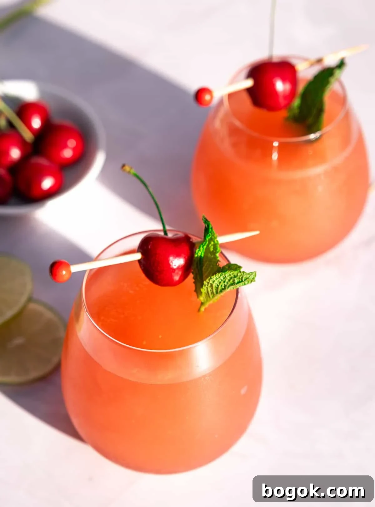 Rosé Wine Slushie Recipe for Ninja SLUSHi Machine 5 Two Rosé Wine slushies in glasses, garnished with mint and cherries.