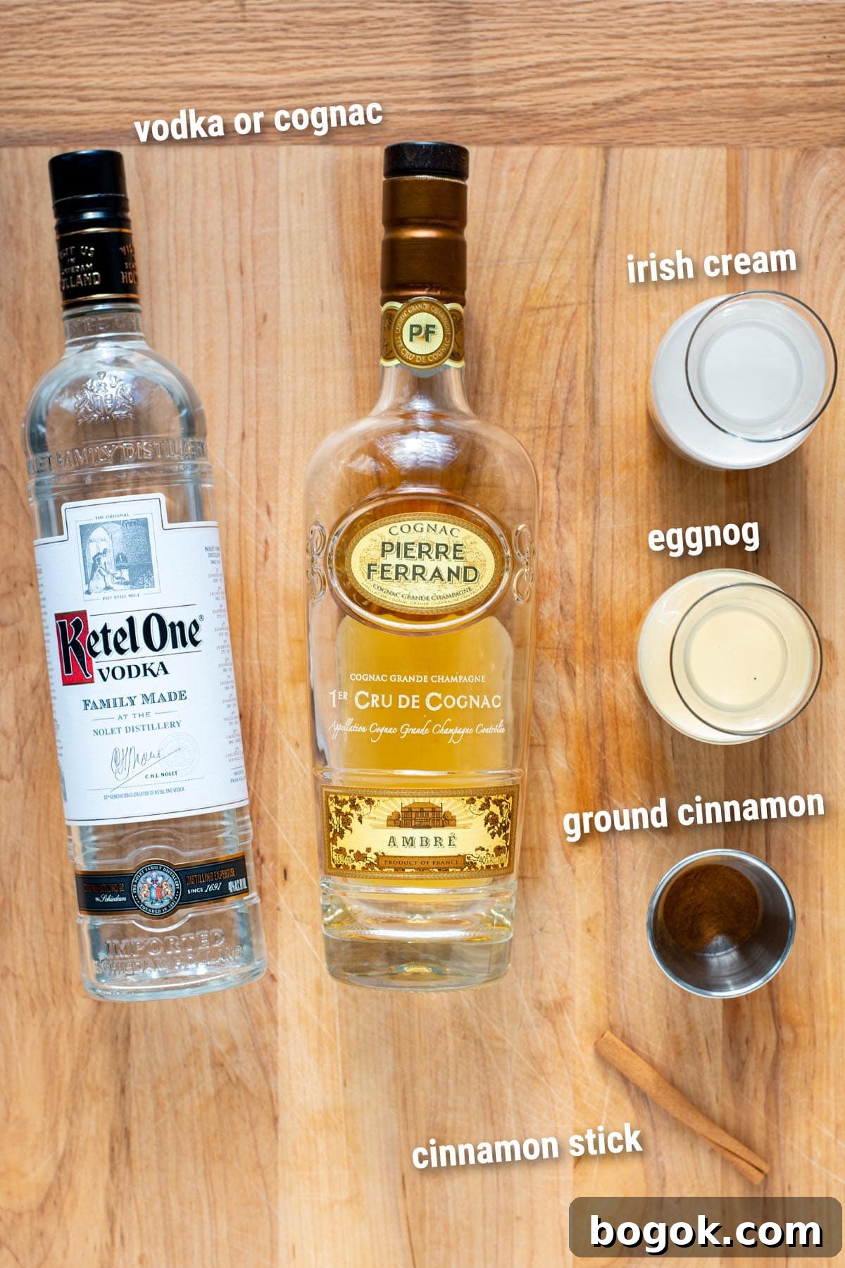 Creamy Eggnog Cocktail Recipe for Holiday Parties 3 Eggnog cocktail ingredients laid out on a wooden cutting board.